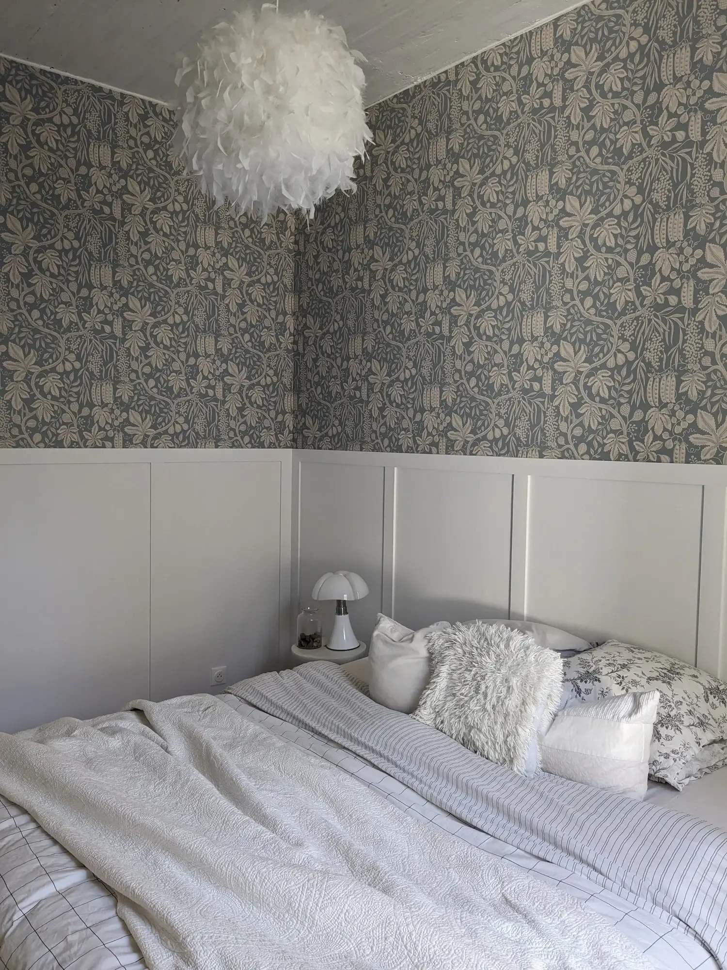 Chambre au papier peint botanique bleu clair, soubassement blanc et suspension plume