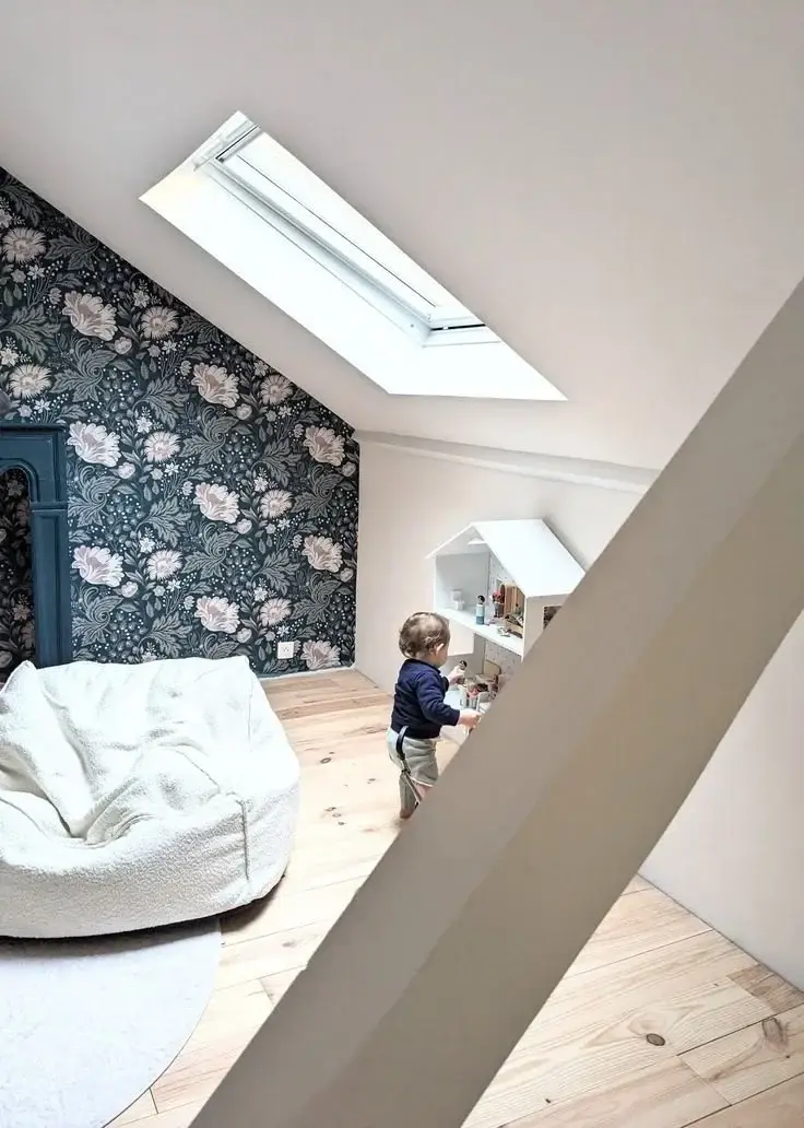 Puits de lumière et grand pouf blanc dans la chambre mansardée