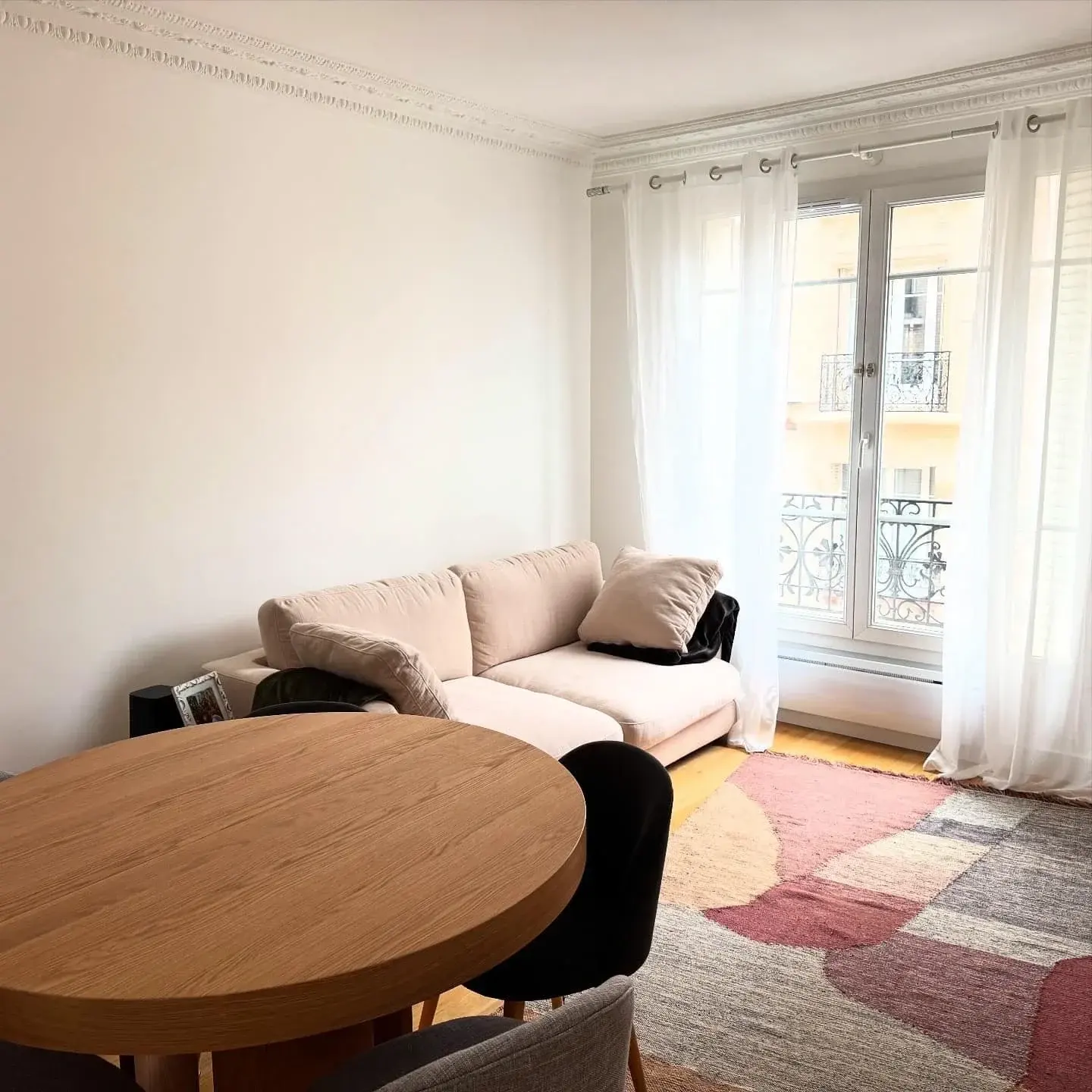 Table ronde en bois et tapis rose et terracotta