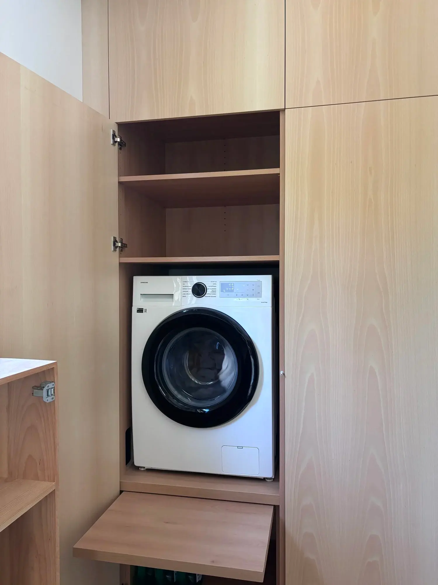 Lave-linge intégré dans un rangement sur mesure en bois clair