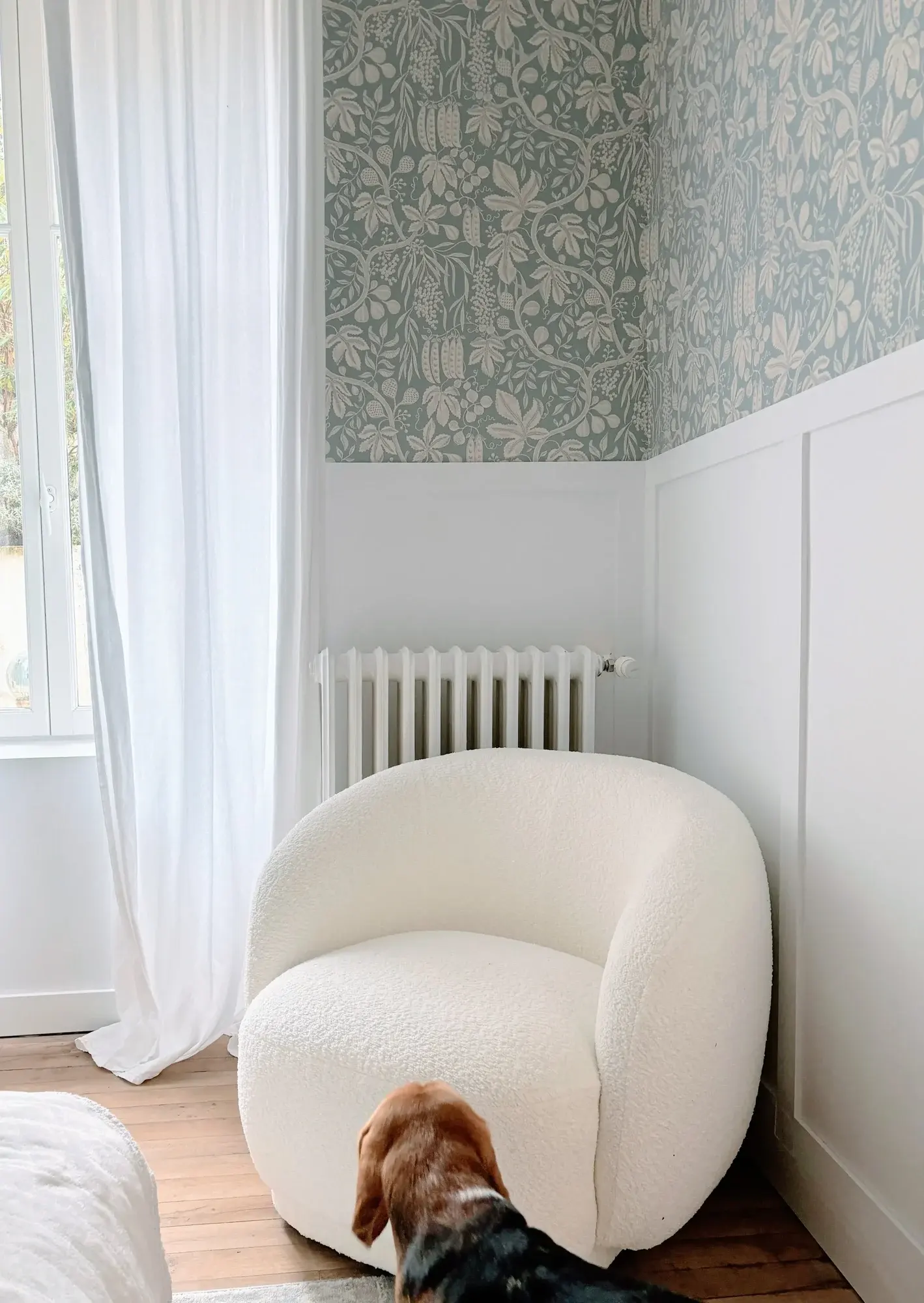Fauteuil bouclette blanc près de la fenêtre